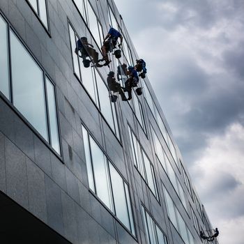 Climbers washing windows of a modern high-rise building