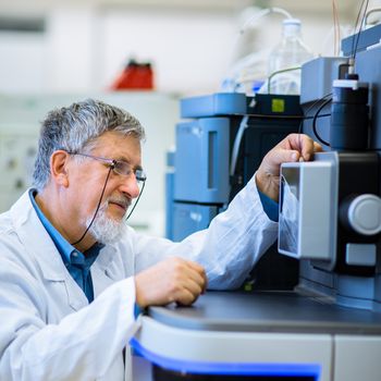 Senior male researcher carrying out scientific research in a lab (shallow DOF; color toned image)