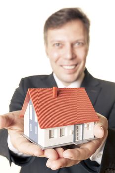 An image of a man holding a house in his hands