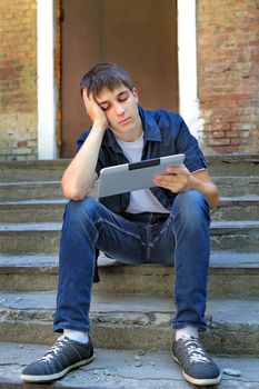 Bored Teenager with Tablet Computer on the landing steps of the House