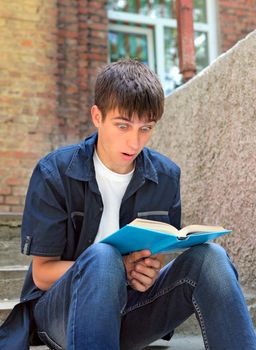 Surprised Teenager with the Book on the landing steps of the House