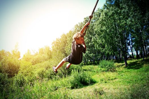 Vignetting Photo of Kid Bungee jumping in the Summer Forest