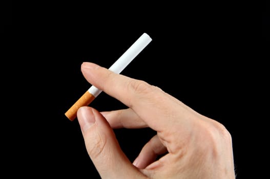 Cigarette in the Hand on the Black Background