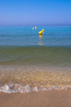 Beach edge waves and buoys. Mallorca, Balearic islands, Spain.