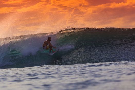 Surfer on Amazing Wave at sunset time, Bali island.