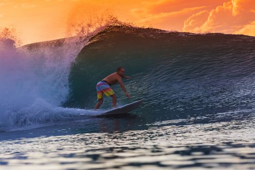 Surfer on Amazing Wave at sunset time, Bali island.