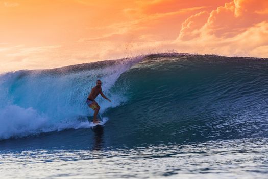 Surfer on Amazing Wave at sunset time, Bali island.