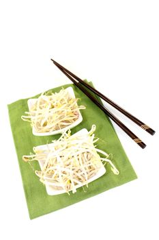 fresh bright mung bean sprouts with chopsticks on a light background