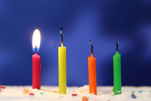 Four lit birthday candles close up, shallow dof
