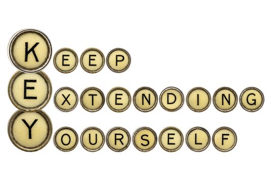 KEY - keep extending yourself - motivation acronym explained in isolated vintage typewrtier keys