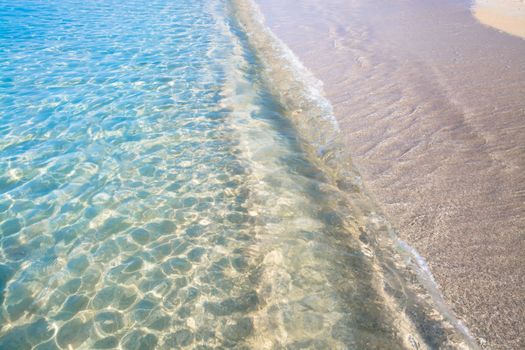 Waters edge. Closeup of sandy beach with crystal clear water, Mallorca, Balearic islands, Spain.