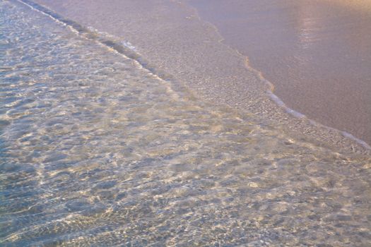 Waters edge. Closeup of sandy beach with crystal clear water, Mallorca, Balearic islands, Spain.