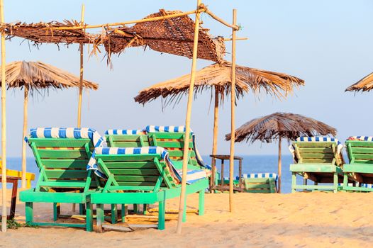 Beach umbrellas and deckchair on the tropical coast in Goa, india