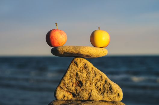 Balancing of apples on the top of triangle stone