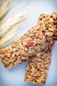 Muesli bars, cereal bars on the wooden background.