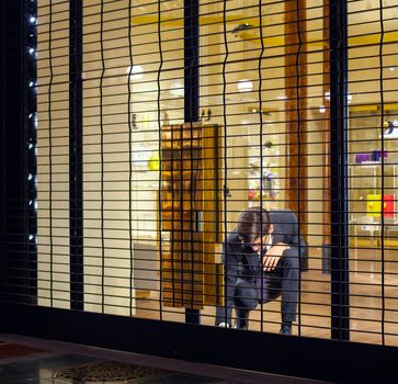 MILAN, ITALY - NOVEMBER, 24: Salesman close shop shutter on November 24, 2014