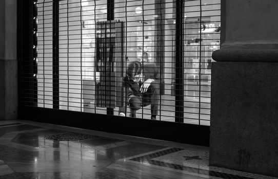 MILAN, ITALY - NOVEMBER, 24: Salesman close shop shutter on November 24, 2014