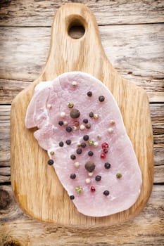 Pork chop, meat slices  on a wood background.