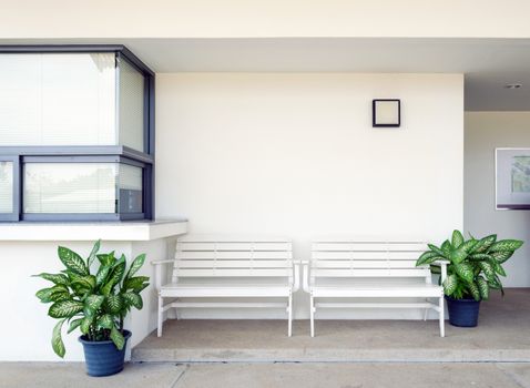 White wooden bench outside of building.