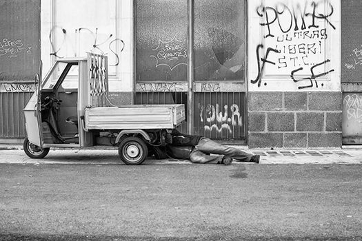 CATANIA, ITALY - DECEMBER, 15: Man under the hood of his three-wheeled on December 15, 2014