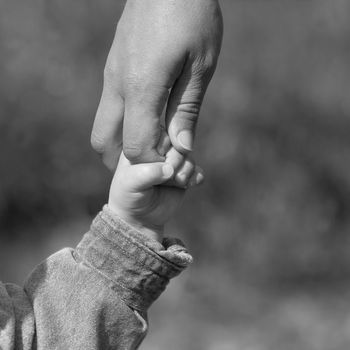 Mother and young son holding hands