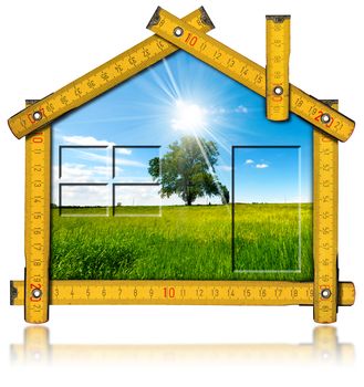 Wooden yellow meter ruler in the shape of house with country landscape with tree inside. Isolated on white background