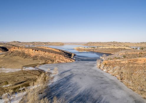 aerial view of partially frozen mountain lake with sandstone cliff at sunset, Horsetooth Reservoir, Fort Collins, Colorado