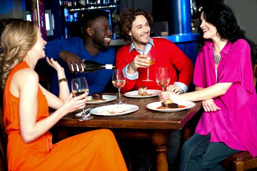 Four friends enjoying drinks at restaurant