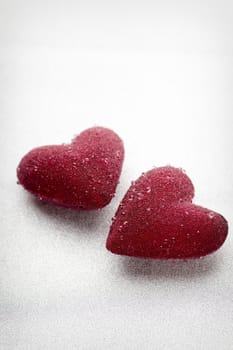 Red hearts tied with a ribbon on a silver background.