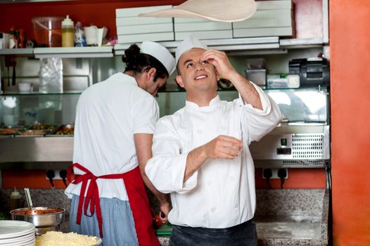 Chef makes the pizza dough spin in the air