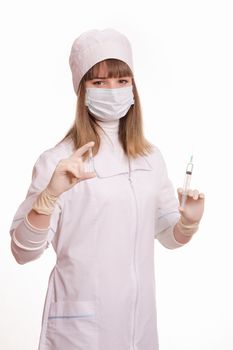 Portrait of medical worker in a white coat, hat, gloves and a mask, with a syringe and vial in hands