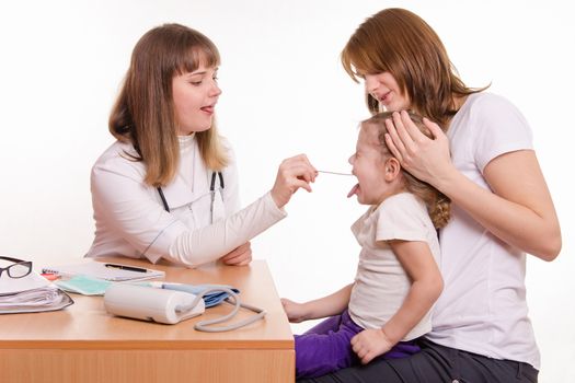Doctor pediatrician examines a sick child at home