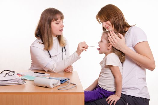 Doctor pediatrician examines a sick child at home