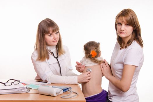 Doctor pediatrician examines a sick child at home