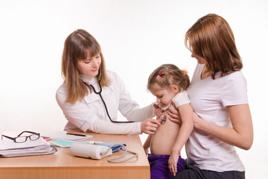 Doctor pediatrician examines a sick child at home