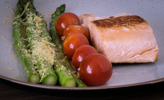 Succulent dish of roasted salmon with asparagus and cherry tomatoes