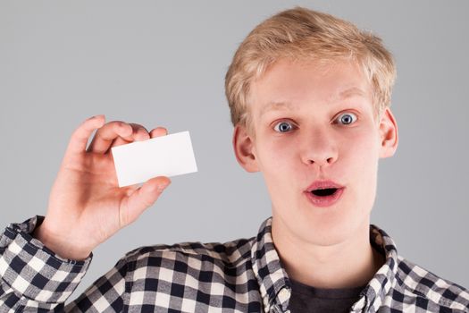 Portrait of young handsome guy holding a blank card