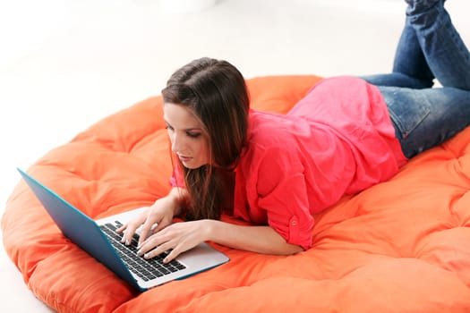 Happy young woman lying on an orange blanket