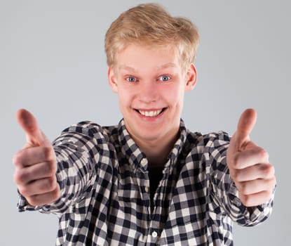 Portrait of young handsome guy over grey background