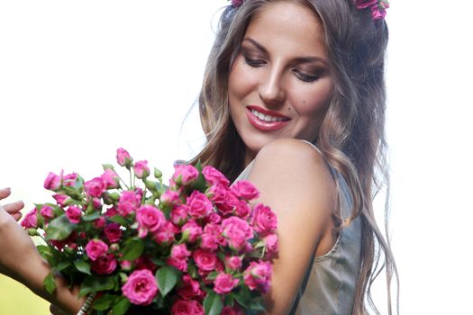 Portrait of a beautiful girl holding bouquet of flowers in the park