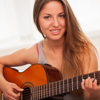Young beautiful caucasian woman in casual playing guitar