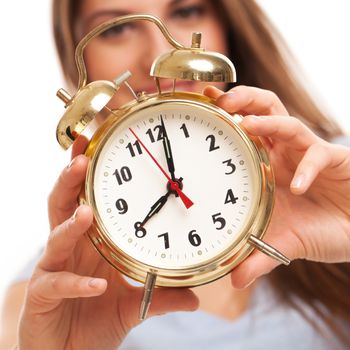 Young caucasian woman with alarm clock in her hands