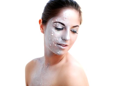 Portrait of a beautiful girl with silver body art over a white background