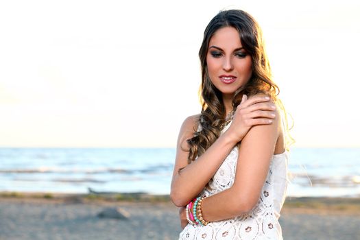 Portrait of a beautiful girl with brown hair who is posing at the beach