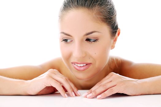 Portrait of a beautiful girl who is lying on her arms and posing over a white background