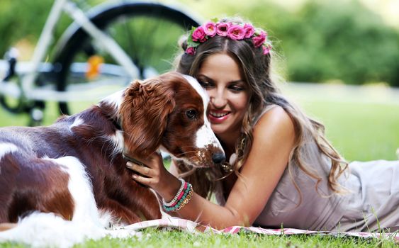 Portrait of a beautiful girl hanging out with a dog in a park