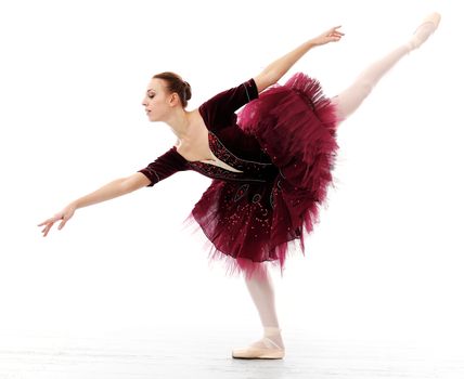 Ballerina in a purple tutu and slippers is working out and dancing over a white background