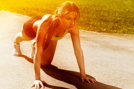 Beautiful young woman getting ready to run from lying pose