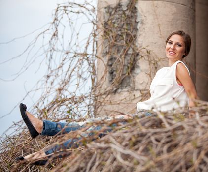 Beautiful young caucasian woman sitting in old vine