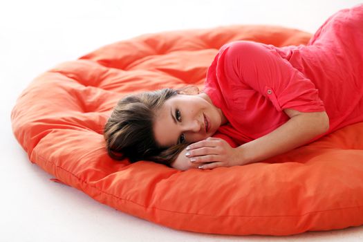 Sensual young woman dreaming on an orange blanket